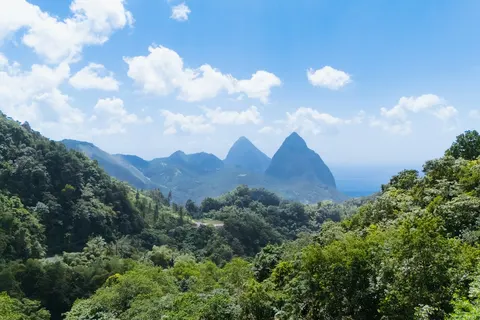 Rainforest-covered hills with the Pitons behind, Saint Lucia